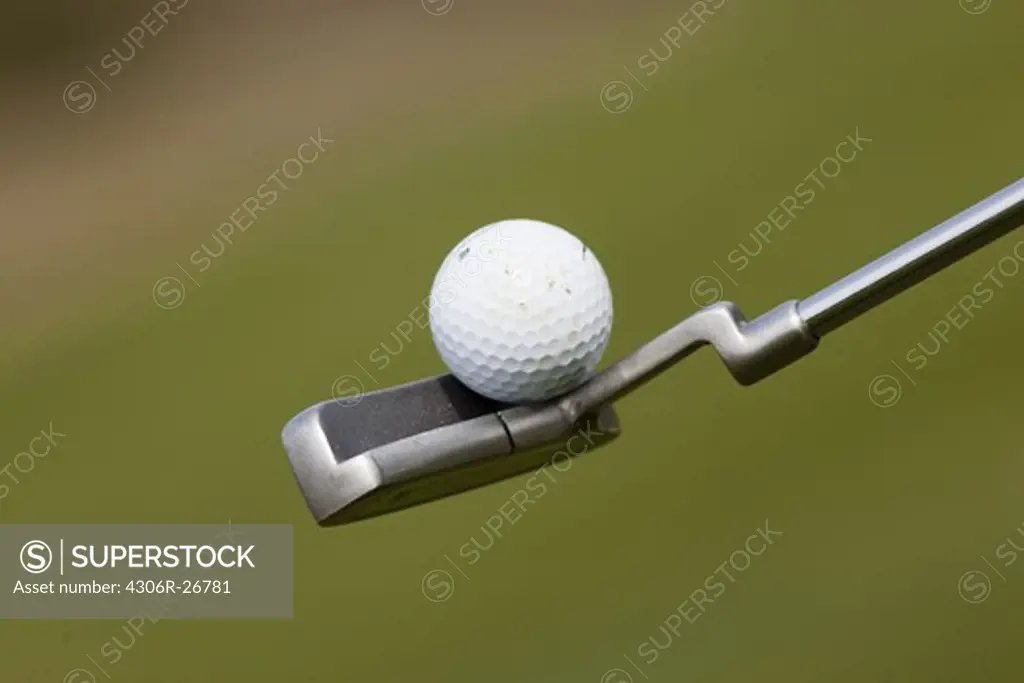 Golf ball balancing on club