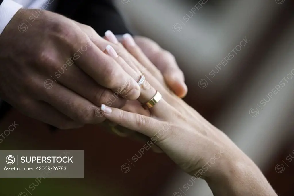 Bridegroom and bride putting on rings