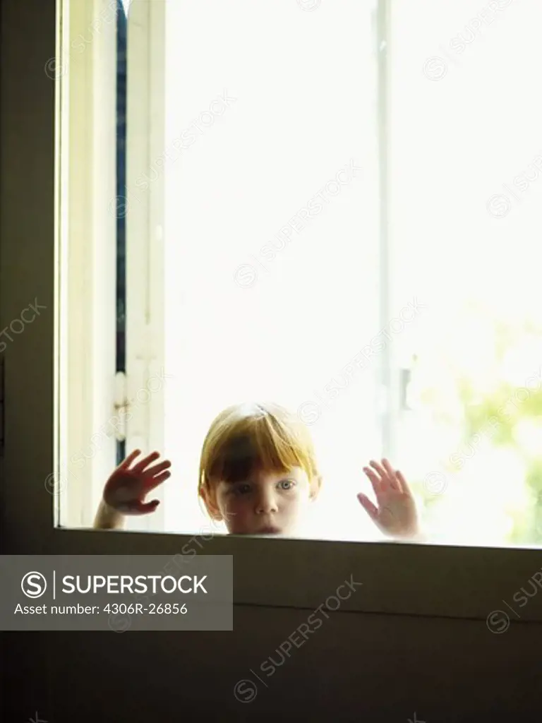 Redhead girl looking through window