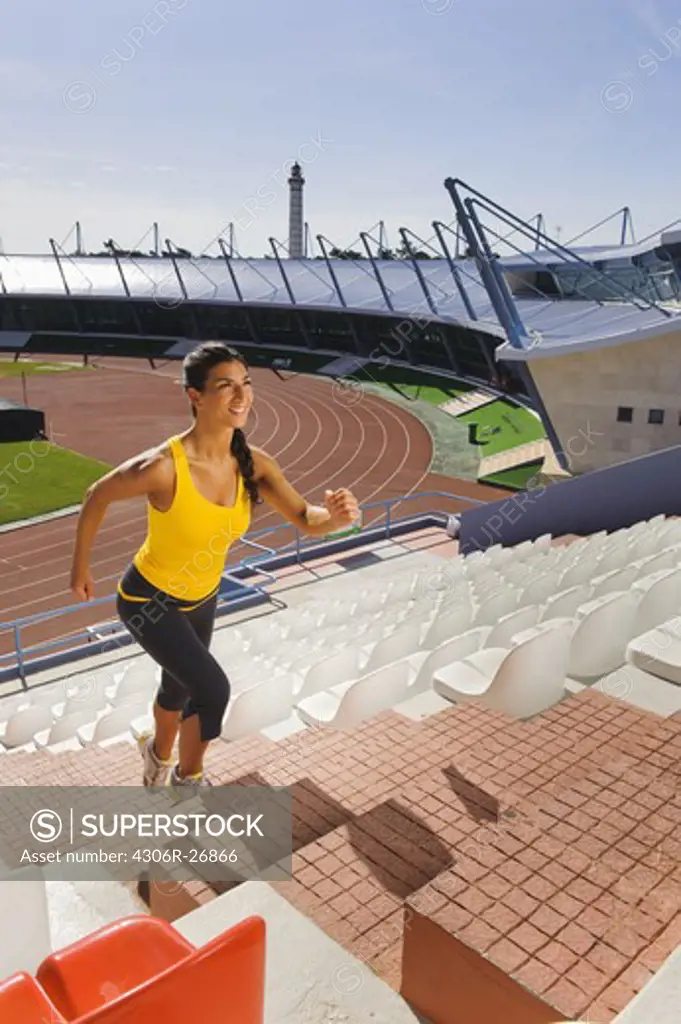 Female athlete running up stadium steps