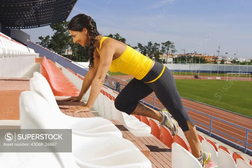 Female athlete exercising at stadium steps