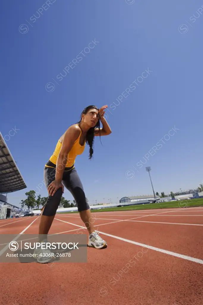 Female athlete standing at stadium