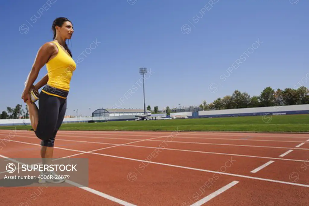 Female athlete stretching at stadium