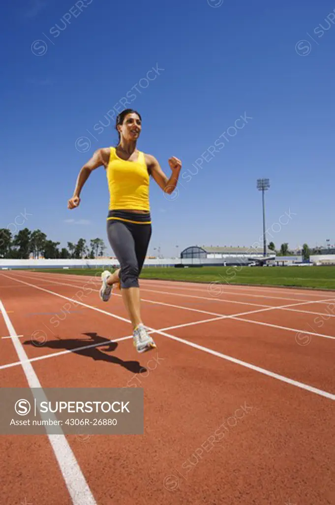 Female athlete sprinting at stadium