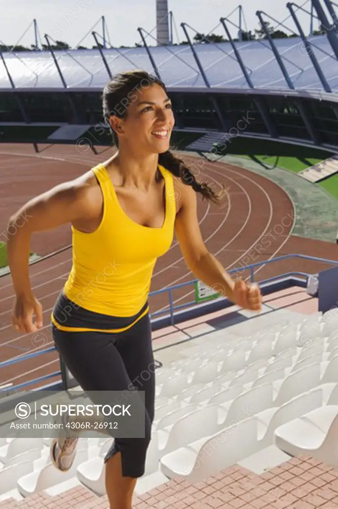 Mid adult woman exercising on stadium