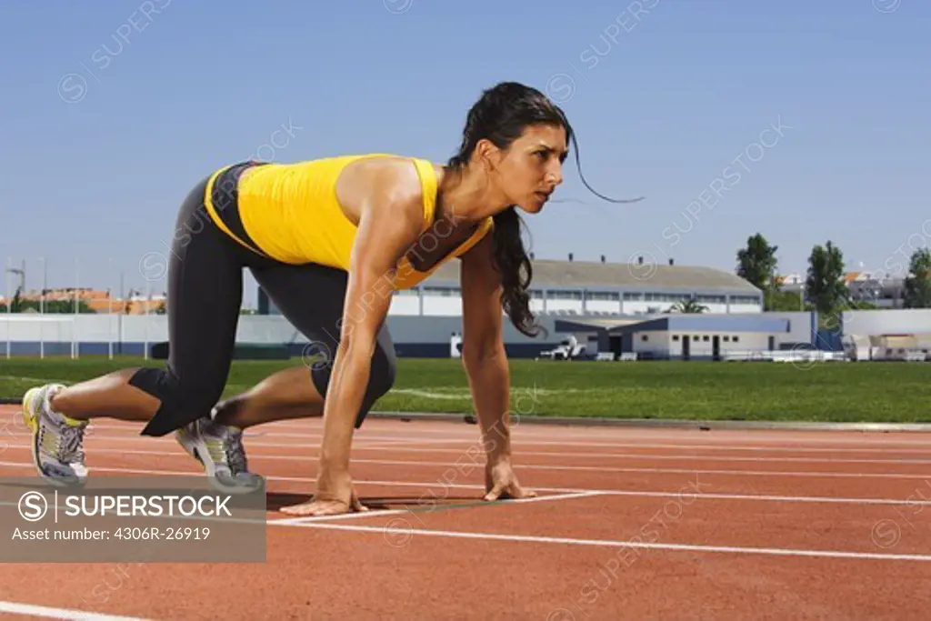Mid adult woman exercising on stadium