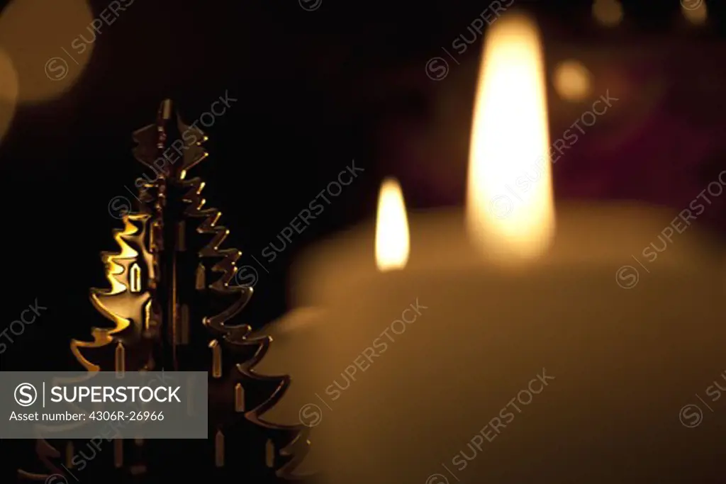 Christmas tree with lit candles in background