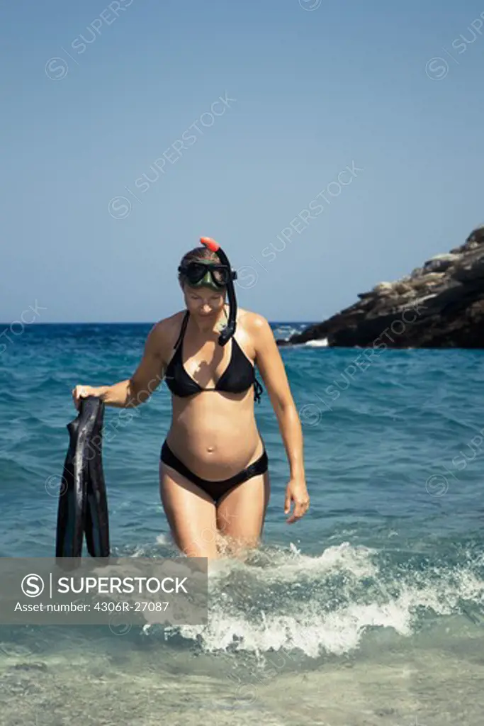 Woman walking in water with snorkelling gear