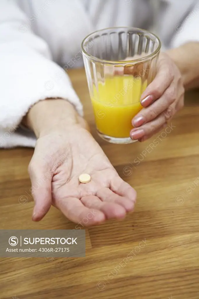 An elderly woman taking her medicine, Sweden.