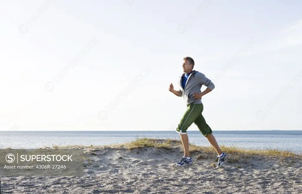 A man jogging on the beach, Malmo, Sweden.