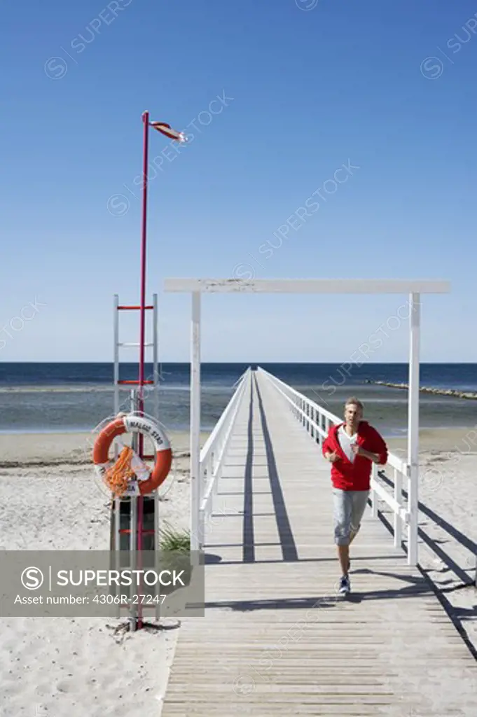 A man jogging on a jetty, Malmo, Skane, Sweden.