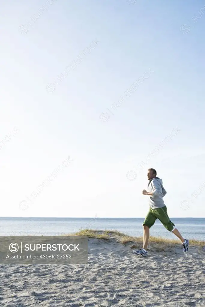 A man jogging on the beach, Malmo, Sweden.