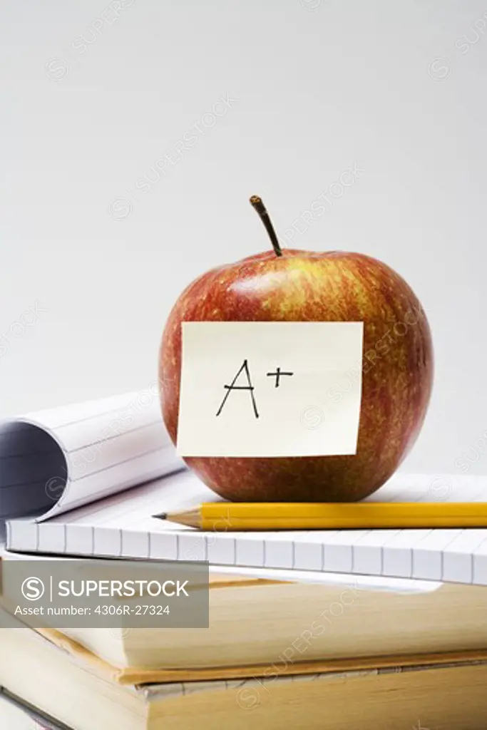 An apple on a note pad, close-up.