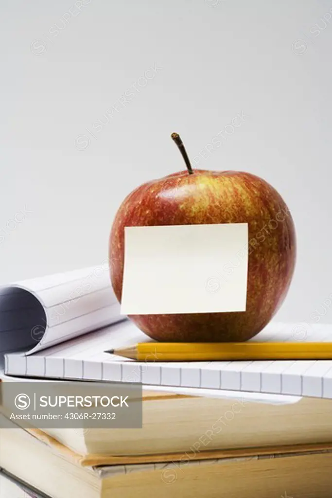 An apple on a stack of books, close-up.