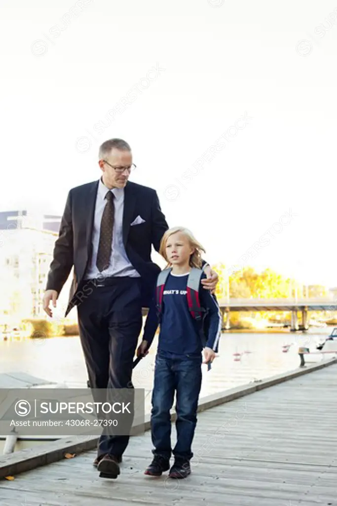 Father and son walking on pier