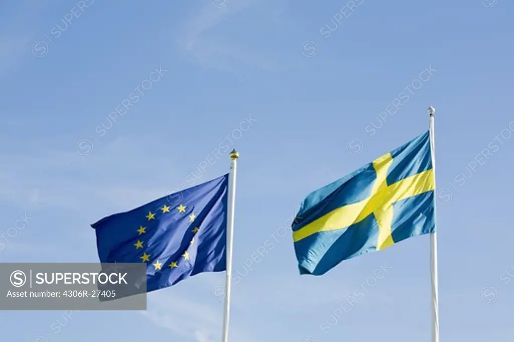 Swedish and EU flag swaying against sky