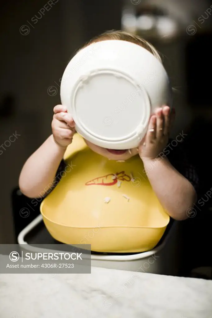 Boy wearing bib eating from bowl