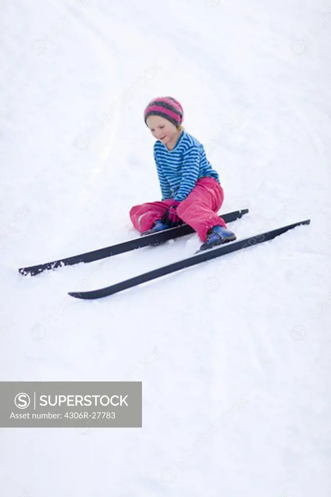 Young girl adjusting skis