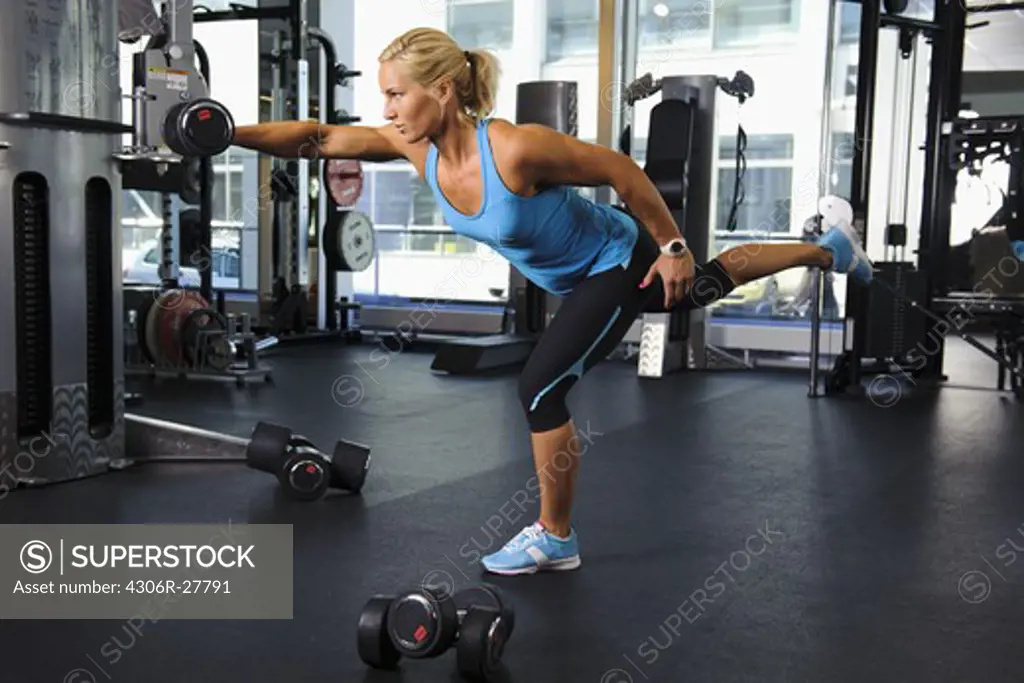 Woman lifting weights in gym