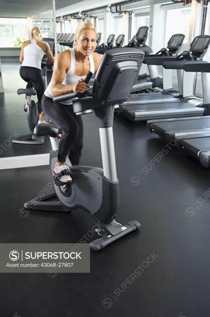 Woman exercising on bike in gym