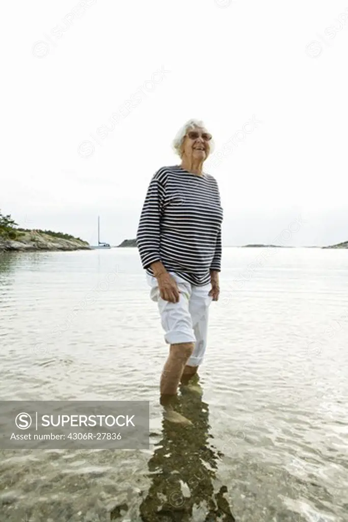 Senior woman wading in lake