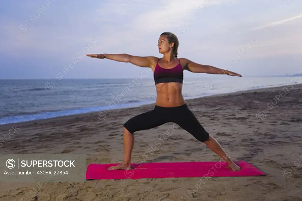 Women doing yoga on beach
