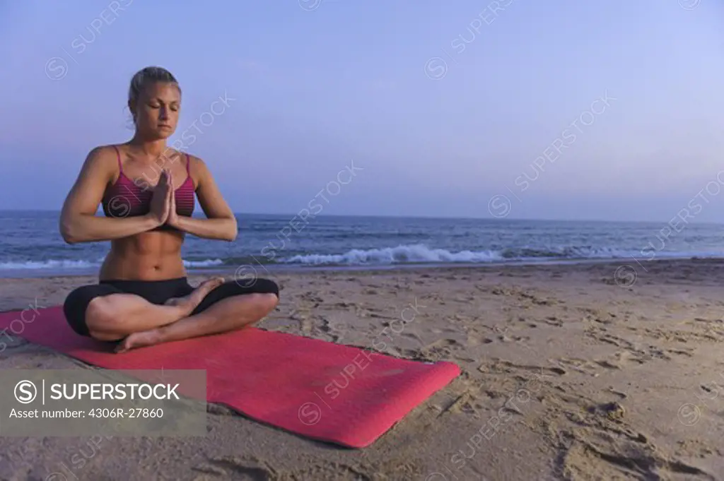 Woman meditating on beach