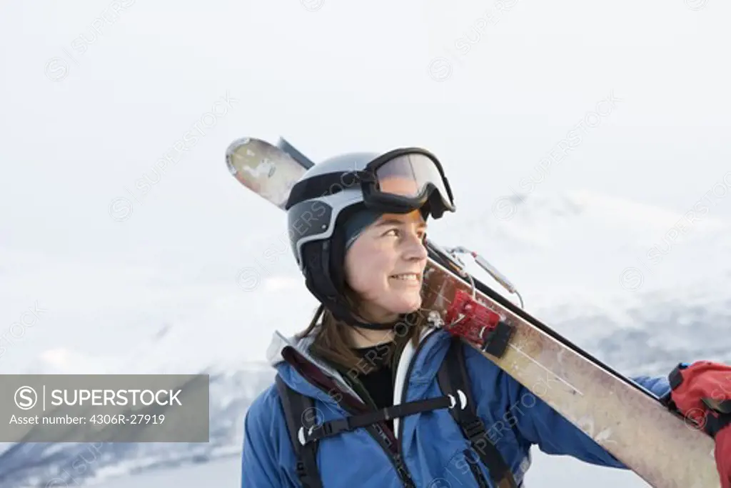 Portrait of woman in ski-wear holding skis