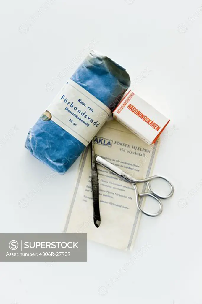 Bandages, scissors and forceps against white background