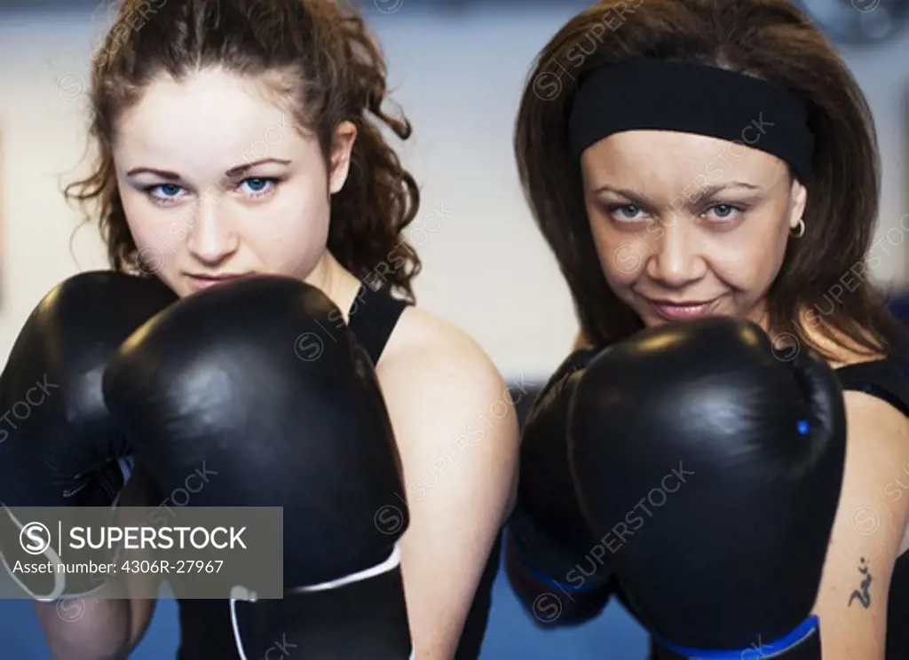 Portrait of two women wearing boxing gloves