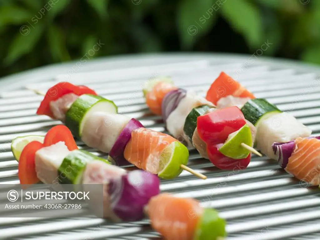 Fish and vegetable skewer in barbecue grill, close-up