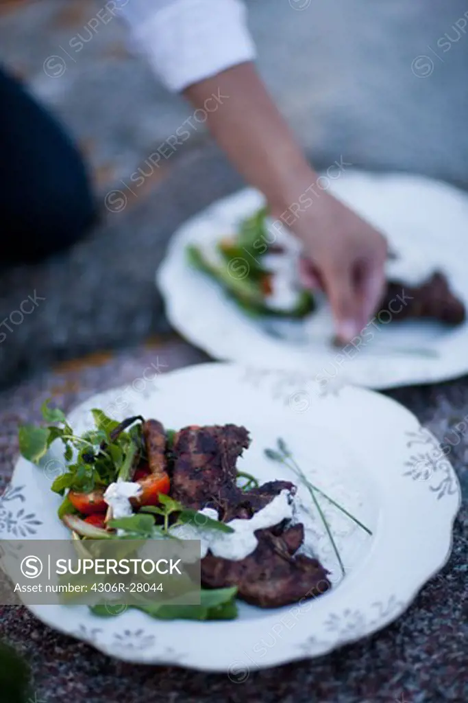 Person garnishing food on plate