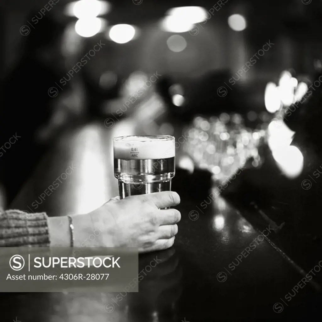 Hand of woman holding beer in bar