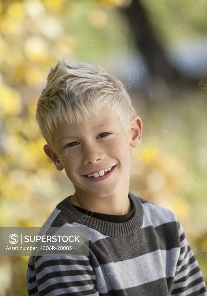 Portrait of blonde boy smiling outside