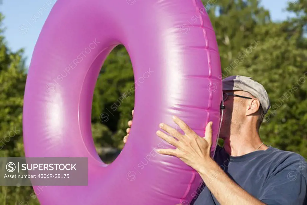 Man blowing inflatable ring