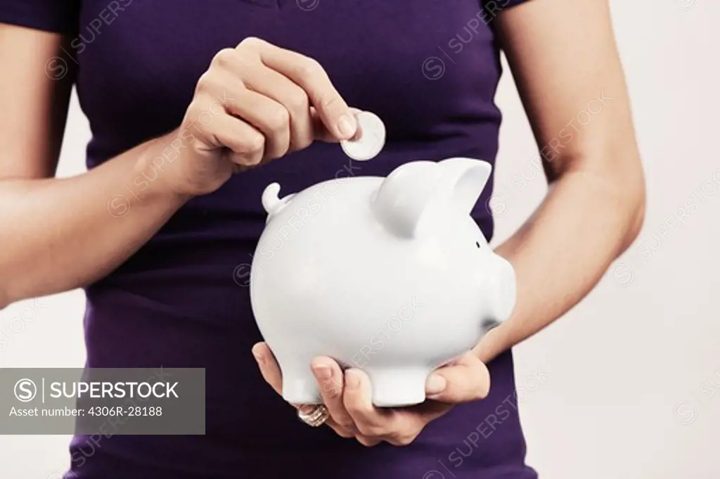 A woman holding a savings box