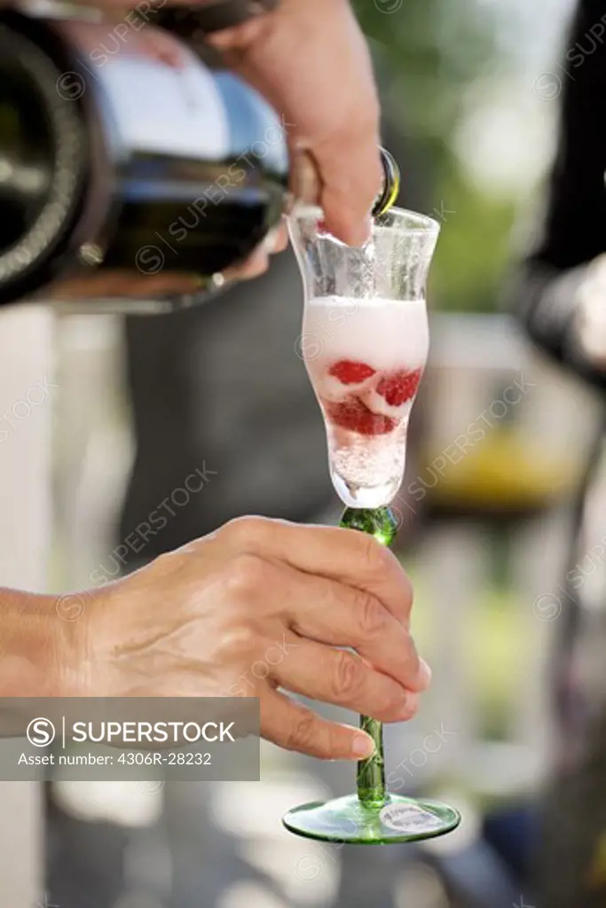 Person pouring champagne into glass