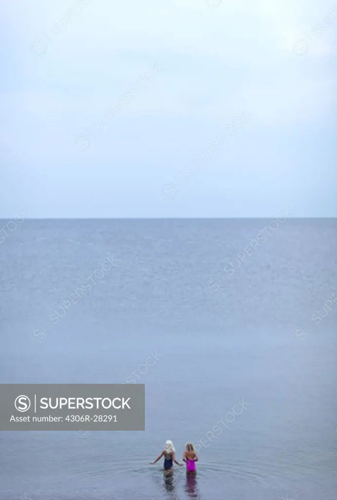 Elevated view of two girls wading in sea