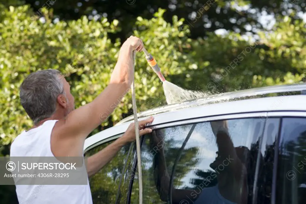 Man washing car with hose