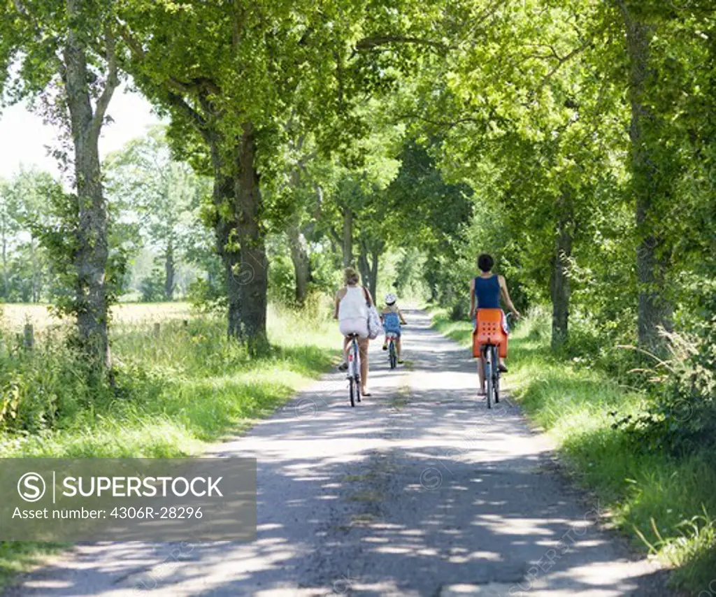 Mother with daughters cycling on rural road