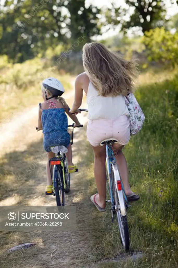 Girls cycling on path