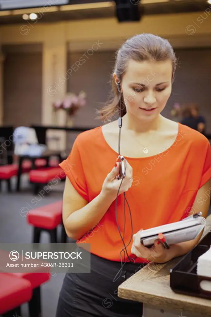 Young woman talking on mobile phone using earbud