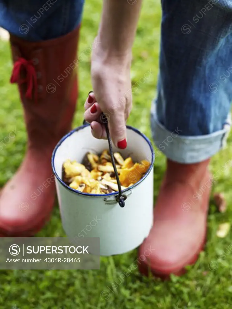 Woman holding bucket of mushrooms