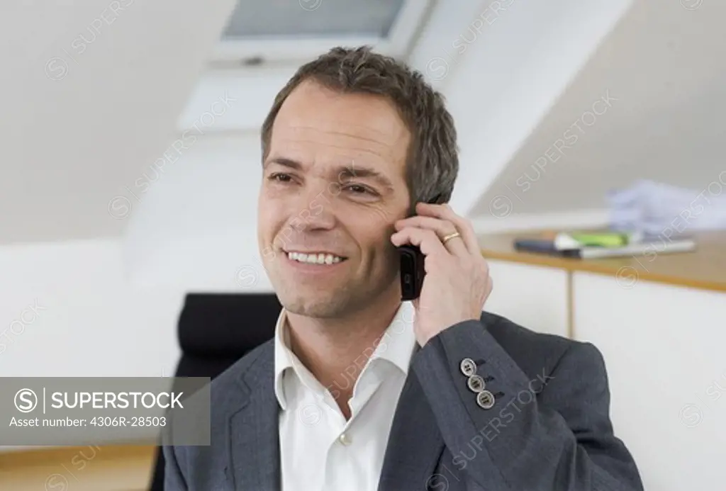 Smiling businessman talking via cell phone