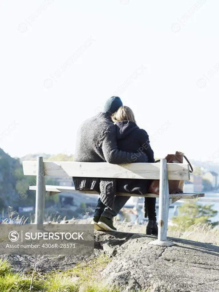 Young couple relaxing on park bench