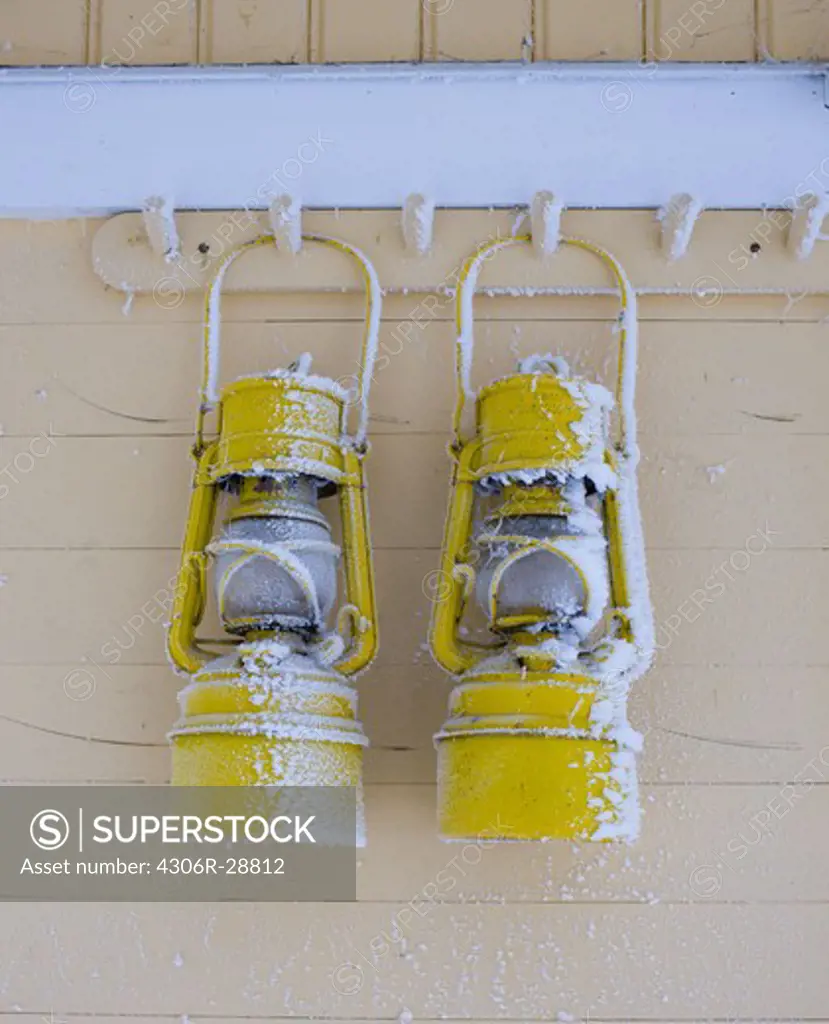 Two frozen lanterns hanging on hook