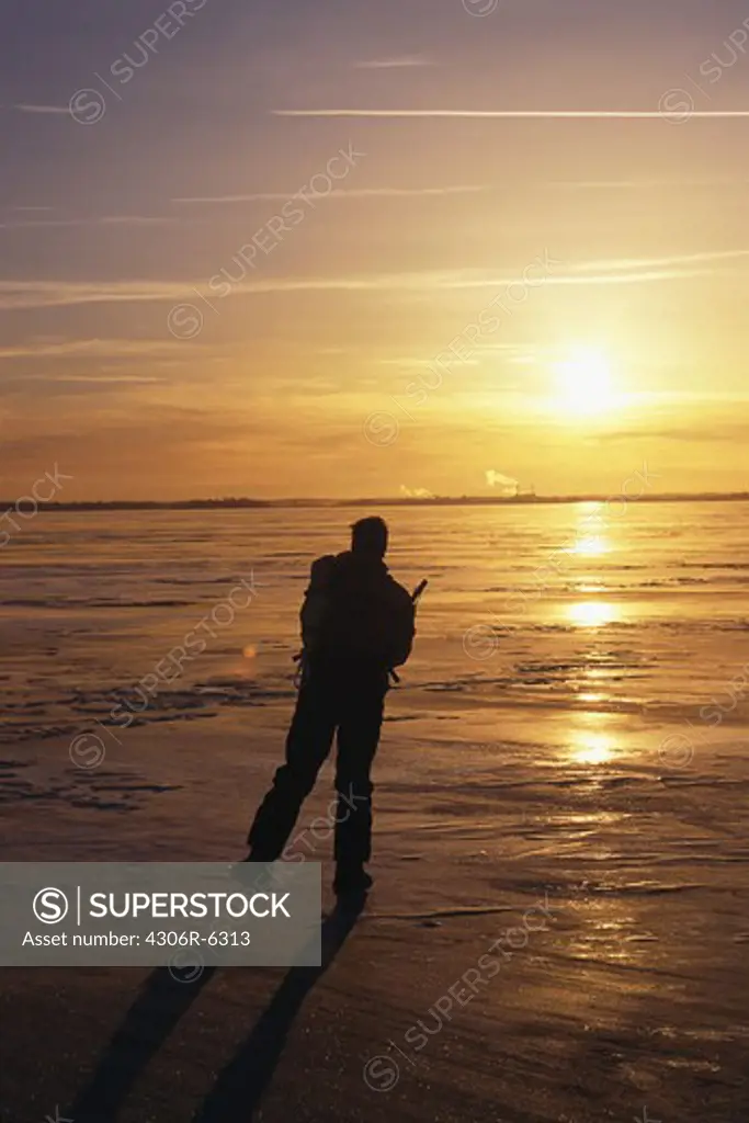 Silhouette of man ice skating at sunset