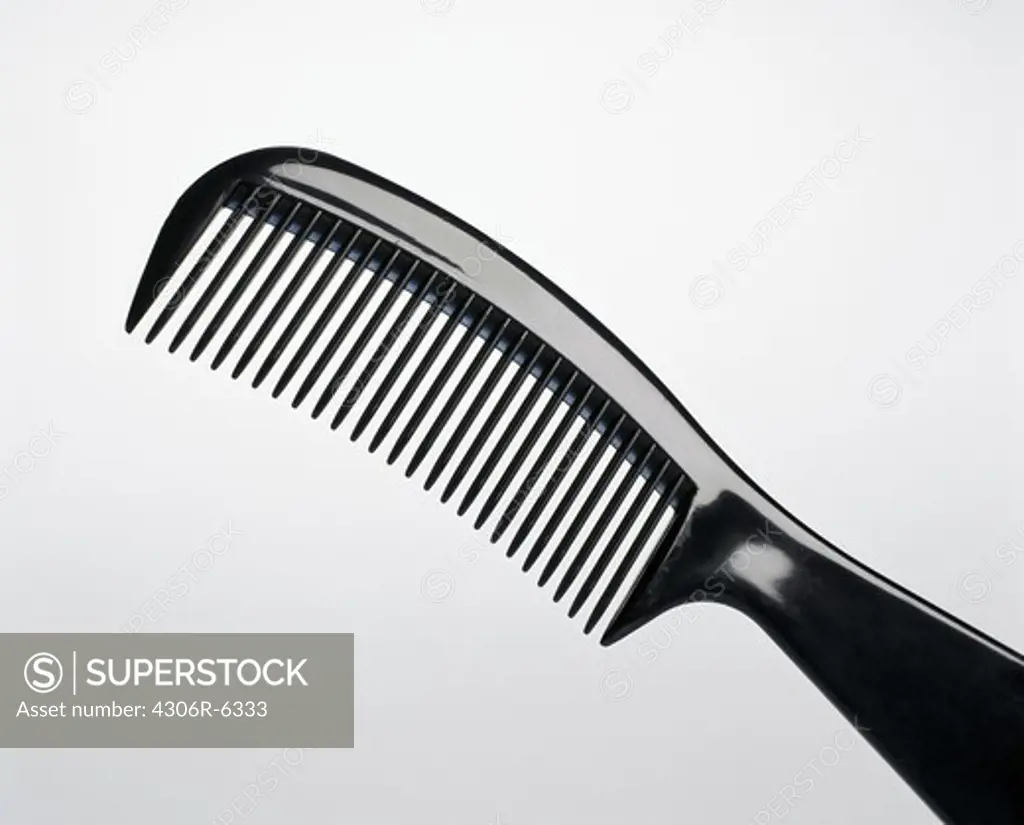 Black hair comb against grey background