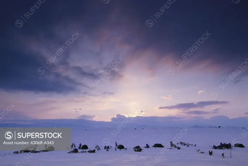 Campers on snow covered landscape at dusk
