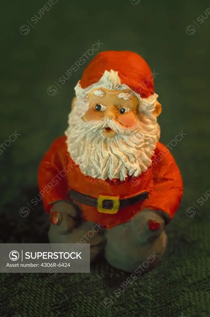 Figurine of Santa Claus on green carpet